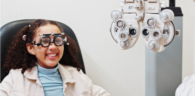 Young girl receiving eye exam with a trial frame for myopia management and treatment planning.]