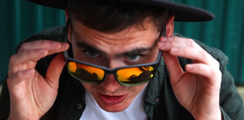 Stylish young man wearing a hat, man adjusting his sunglasses