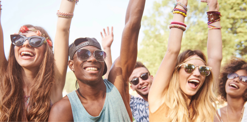 Festival-goers wearing sunglasses and enjoying an outdoor festival