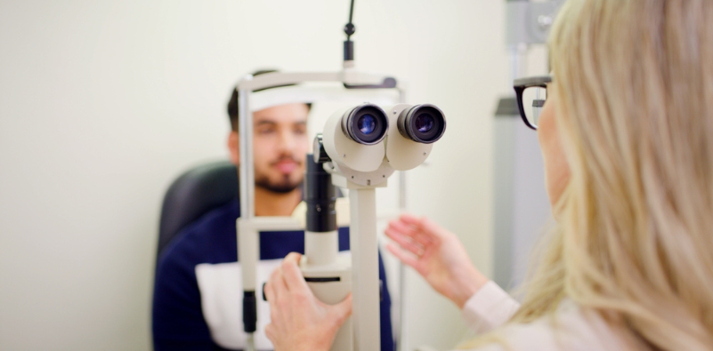 A man having an eye examination with a female optometrist